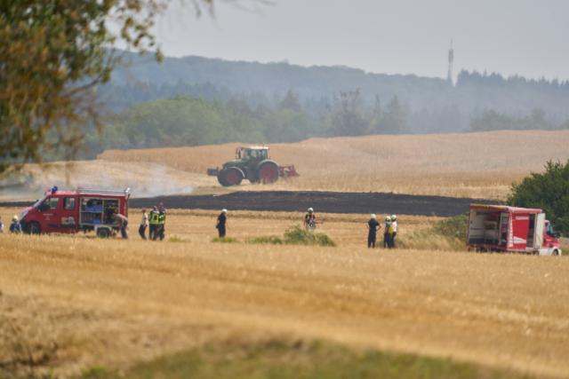 30 July 2026, Rhineland-Palatinate, Bornich: Firefighters work to extinguish a fast-spreading wildfire in an agricultural field near Bornich. Photo: Thomas Frey/dpa