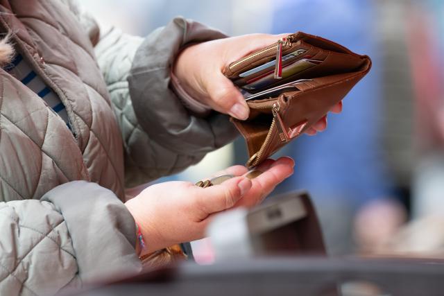 FILED - 15 May 2026, Sachsen, Dresden: FILE PHOTO - A woman holds an open wallet at a weekly market. Photo: Sebastian Kahnert/dpa