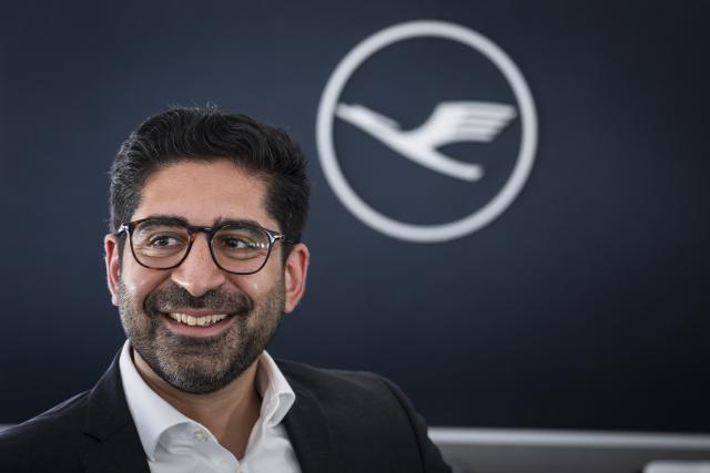 30 July 2026, Hesse, Frankfurt am Main: Hessen Minister of Economic Affairs, Energy, Transportation, Housing, and Rural Affairs Kaweh Mansoori stands in front of a wall bearing the Lufthansa logo inside the new Boeing 787-9. Photo: Hannes P. Albert/dpa