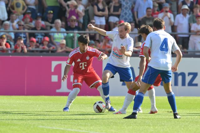 30 July 2026, Bavaria, Rottach-Egern: Bayern Munich's Tom Bischof (2nd R) and Maycon Cardoso (L) battles for the ball with Rottach-Egern's Tobias Schlichtner and Marinus Trettenhann during the Friendly soccer match between FC Rottach-Egern and FC Bayern Munich. Photo: Peter Kneffel/dpa - WICHTIGER HINWEIS: Gemäß den Vorgaben der DFL Deutsche Fußball Liga bzw. des DFB Deutscher Fußball-Bund ist es untersagt, in dem Stadion und/oder vom Spiel angefertigte Fotoaufnahmen in Form von Sequenzbildern und/oder videoähnlichen Fotostrecken zu verwerten bzw. verwerten zu lassen.