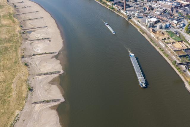 FILED - 30 July 2026, North Rhine-Westphalia, Duisburg: Ships sail in the channel on the Rhine in Duisburg, amid low water levels that have exposed wide sandbars, normally submerged, along the shore. Photo: Christoph Reichwein/dpa