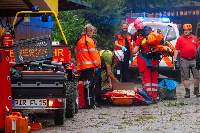 31 July 2026, Saxony, Rathen: Emergency responders stand near the Felsenbuehne Rathen, where a man has died in a storm in Saxony after killing by a fallen tree. Photo: Jonas Schubert/xcitepress/dpa