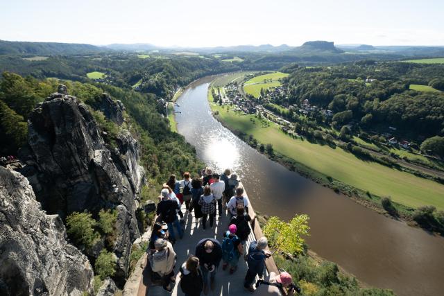 FILED - 27 September 2024, Saxony, Lohmen: File Photo - Tourists stand on a viewing platform on the Bastei Rock in Saxon Switzerland National Park. Photo: Sebastian Kahnert/dpa