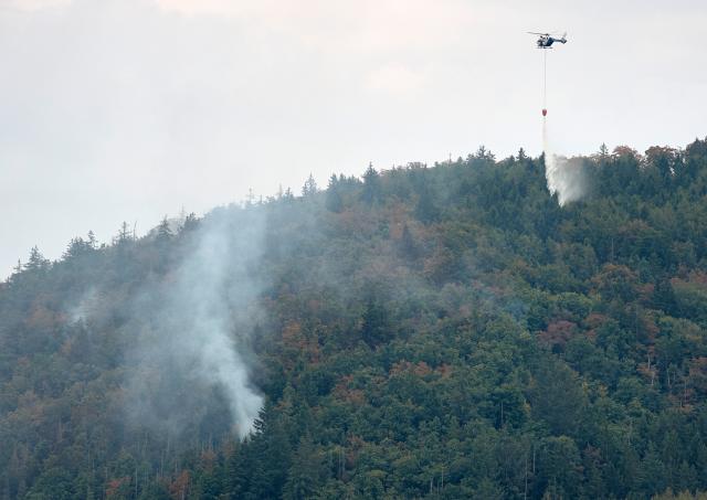 01 August 2026, Bavaria, Freudenberg: Police helicopters are attempting to contain a wildfire in the Amberg-Sulzbach district. Four firefighters were injured while battling the wildfire. Photo: Tizian Gerbing/dpa