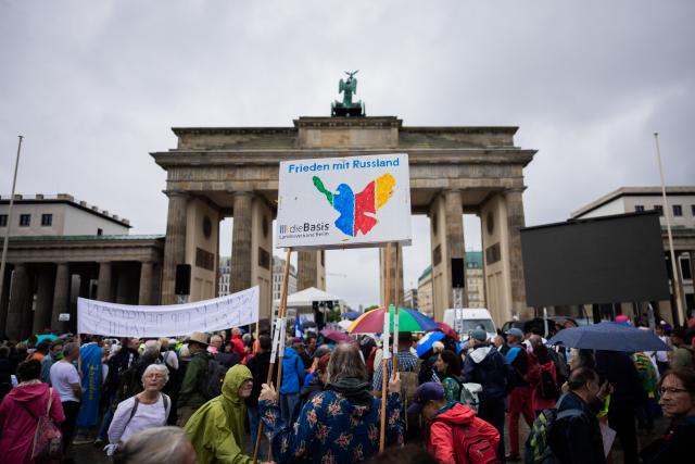 01 August 2026, Berlin: Participants in a demonstration organized by the "Wir sind viele" coalition are protesting in front of the Brandenburg Gate under the slogan "Let's go to Berlin for peace, freedom, fundamental rights, and a genuine reckoning with the coronavirus pandemic." Photo: Christoph Soeder/dpa