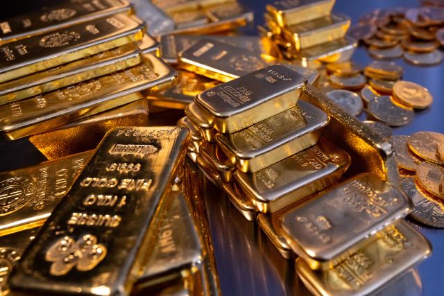 FILED - 16 March 2023, Bavaria, Munich: FILE PHOTO - Gold bars and coins lie on the table at the Precious metal dealership Pro Aurum. Photo: Sven Hoppe/dpa