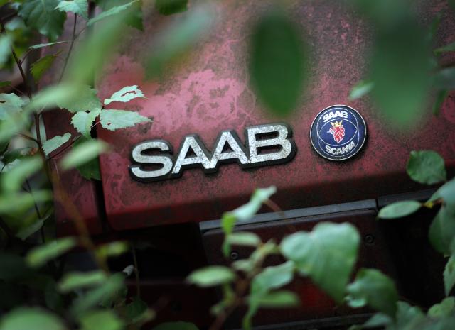 FILED - 07 September 2011, Hamburg: FILE PHOTO - The Saab logo is pictured on the trunk of a car in a junkyard in Hamburg. Photo: Christian Charisius/dpa