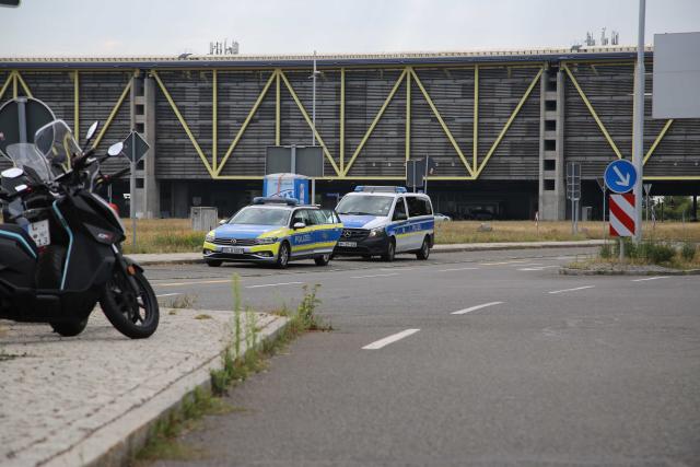 05 August 2026, Saxony, Schkeuditz: Two police vehicles are parked at Leipzig/Halle Airport. Leipzig/Halle Airport suspended flight operations overnight after an unidentified flying object and a suspicious item were found. Photo: Tobias Junghanns/dpa