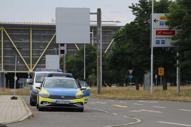 05 August 2026, Saxony, Schkeuditz: Police vehicles are parked in front of the airport administration entrance at Leipzig/Halle Airport. The airport temporarily suspended flight operations overnight after an unidentified flying object was found. Photo: Tobias Junghanns/dpa