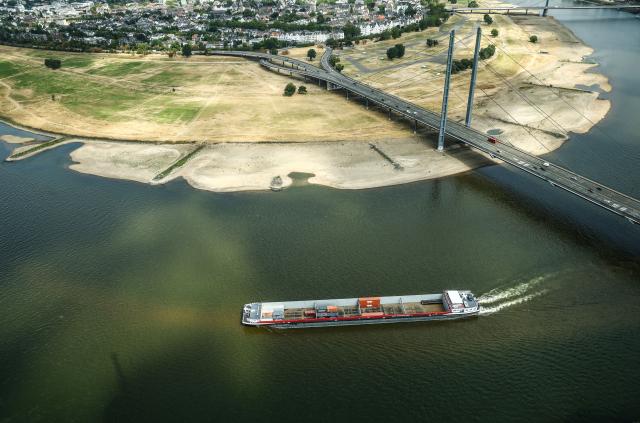 05 August 2026, North Rhine-Westphalia, Duesseldorf: A container ship with a light cargo passes by Duesseldorf, the capital of North Rhine-Westphalia, at the Rhine Bend, during low water. Photo: Oliver Berg/dpa
