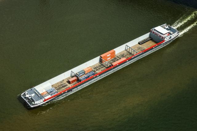 05 August 2026, North Rhine-Westphalia, Duesseldorf: A container ship sails down the Rhine with a light cargo, during low water. Photo: Oliver Berg/dpa