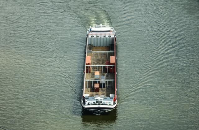 05 August 2026, North Rhine-Westphalia, Duesseldorf: A container ship sails down the Rhine with a light cargo, during low water. Photo: Oliver Berg/dpa
