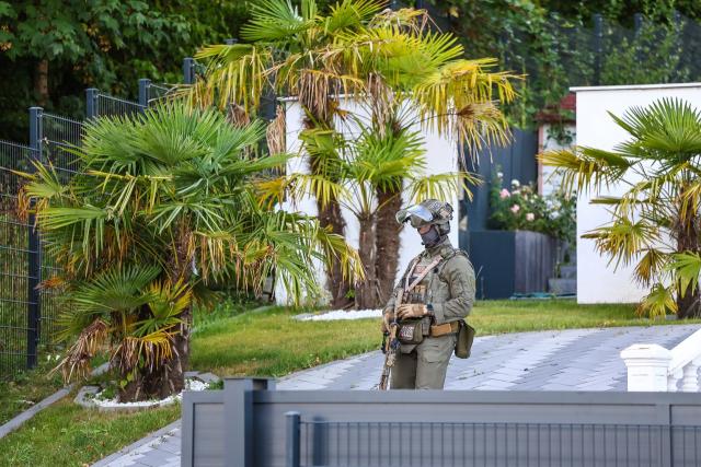 06 August 2026, North Rhine-Westphalia, Hagen: An officer stands in the driveway of a residential building. Around 250 officers from the Dortmund Main Customs Office's unit for combating illegal employment search several properties. Photo: Alex Talash/dpa