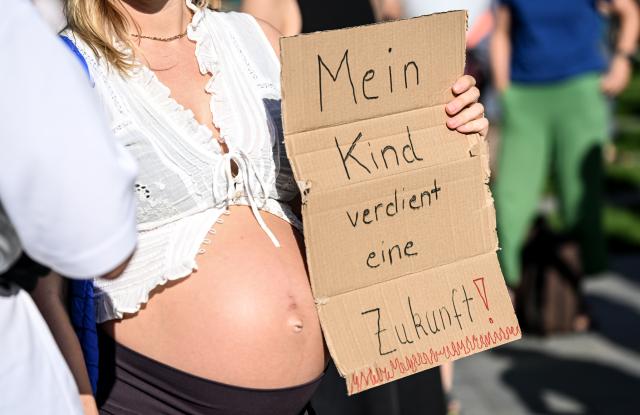 06 August 2026, Berlin: A pregnant woman holds a sign reading "My child deserves a future" at a demonstration organized by the climate movement "Fridays for Future." Photo: Britta Pedersen/dpa - ATTENTION: editorial use only in connection with the latest coverage and only if the credit mentioned above is referenced in full
