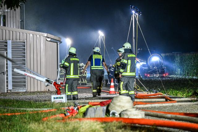 06 August 2026, Bavaria, Ried: Firefighters respond to a fire at a pig barn. More than 1,000 pigs die in a fire at a farm in Bavaria. Photo: Jason Tschepljakow/dpa