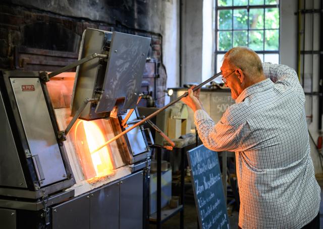 07 August 2026, Brandenburg, Baruth: Pavel Hasala, a glassmaker from the Czech Republic, works in the museum workshop in Glashuette. On August 8, Brandenburg's statewide Industrial Heritage Day will be officially launched in the historic glassmaking village of Glashuette near Baruth. At eight locations across Brandenburg, visitors can gain insights into technology, art, literature, and local history. Photo: Patrick Pleul/dpa