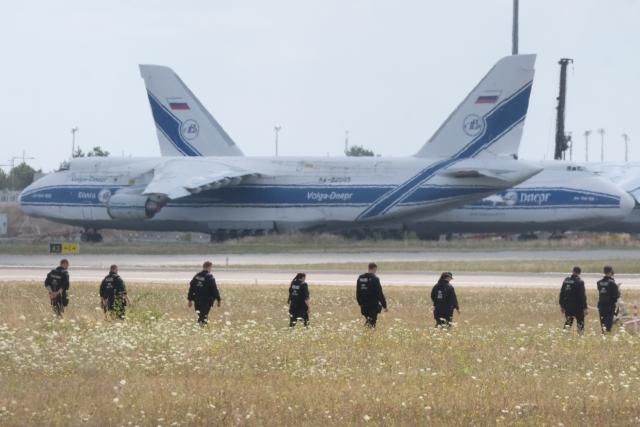 07 August 2026, Saxony, Schkeuditz: Police officers walk across a field on the grounds of Leipzig/Halle Airport. The investigation into the discovery of a drone carrying an explosive device is ongoing. Numerous police officers search the area on foot near the northern runway. Photo: Sebastian Willnow/dpa
