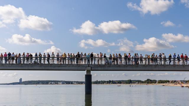08 August 2026, Schleswig-Holstein, Haffkrug: Spectators stand on a pier during an event. Photo: Markus Scholz/dpa