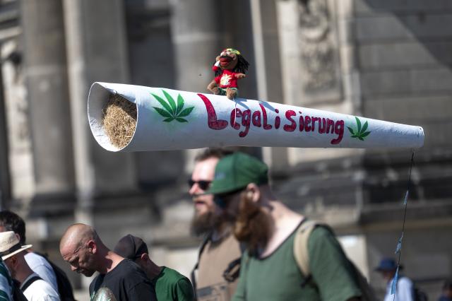 08 August 2026, Berlin: A participant carries a model of a joint with the word "Legalization" written on it, during in the 2026 Hemp parade, held under the slogan "Fair! Healthy! Enjoy!". Photo: Christophe Gateau/dpa