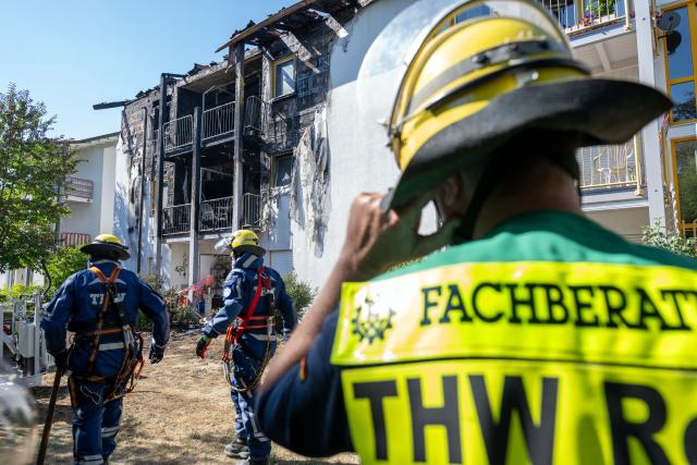 08 August 2026, Bavaria, Rednitzhembach: Emergency responders stand infront of the burned facade of a senior living facility, after a fire broke out. The residents were evacuated. Photo: Pia Bayer/dpa