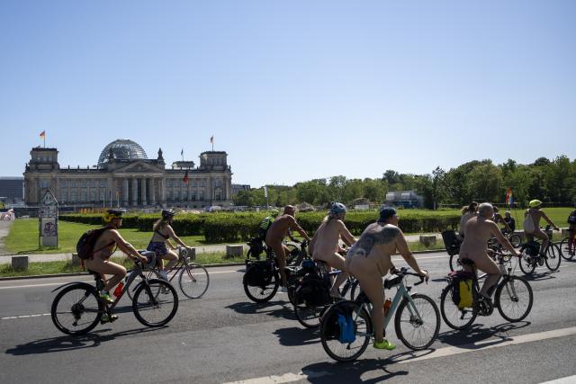 09 August 2026, Berlin: Participants in the "World Naked Bike Ride (WNBR) Berlin 2026" bike rally are riding their bikes through the government district near the Reichstag building. Through this event, the participants are advocating for bodily freedom, mutual respect, and positive coexistence. Photo: Christophe Gateau/dpa
