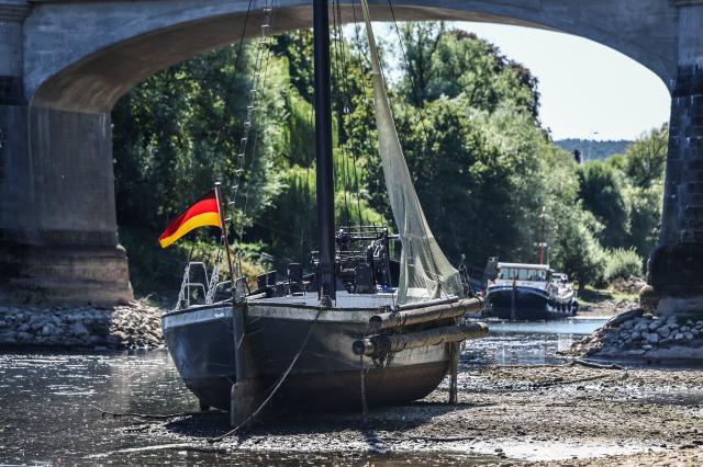 10 August 2026, North Rhine-Westphalia, Bad Honnef: A ship has run aground in a branch of the Rhine near Grafenwerth Island. Water levels on the Rhine remain at historically low levels. Photo: Oliver Berg/dpa