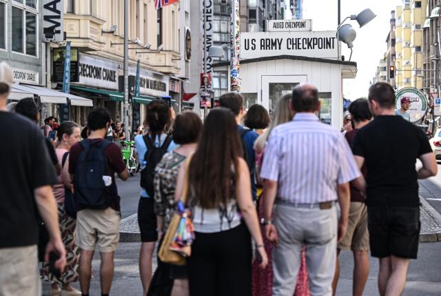 10 August 2026, Berlin: Tourists arrive at Checkpoint Charlie. Photo: Britta Pedersen/dpa