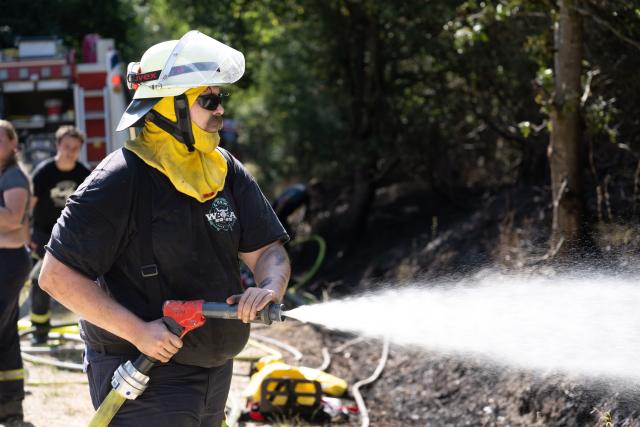 10 August 2026, Hesse, Bad Schwalbach: A firefighter battles a wildfire in the Rheingau. Photo: Boris Roessler/dpa