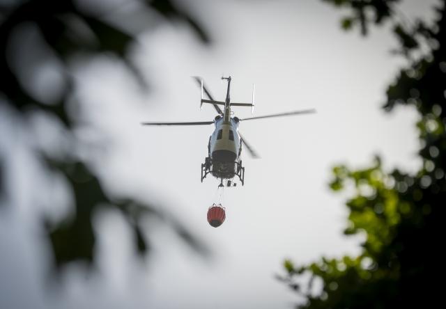 10 August 2026, Hesse, Rodenbach: A firefighting helicopter takes part in firefighting operations as a forest fire burns in Rodenbach. Photo: Andreas Arnold/dpa