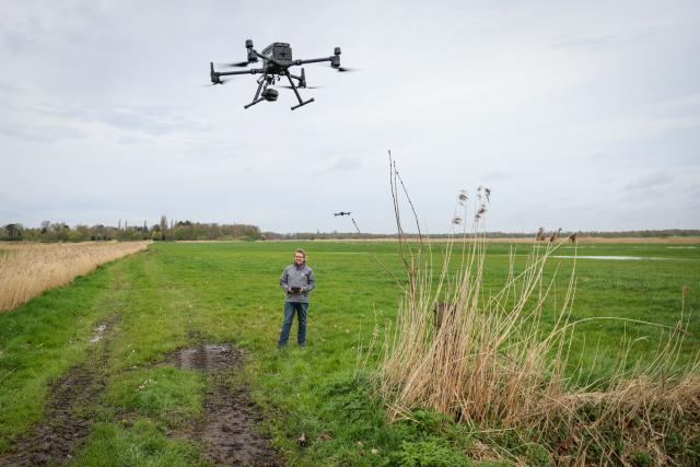 FILED - 05 April 2024, Lower Saxony, Stuhr: FILE PHOTO - Alexander Wulf of Droniq controls a drone over a meadow in Stuhr during a presentation. The drone is designed to identify certain features on the meadow during a flyover, enabling the farmer to apply for targeted subsidies for the land. Photo: Focke Strangmann/dpa