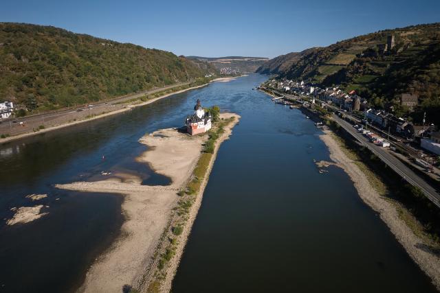 11 August 2026, Rhineland-Palatinate, Kaub: An aerial view, taken with a drone, showing low water levels exposing large sections of the sandbar surrounding the Zollburg Pfalzgrafenstein. Photo: Thomas Frey/dpa