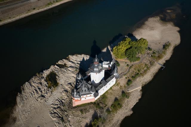11 August 2026, Rhineland-Palatinate, Kaub: An aerial view, taken with a drone, showing low water levels exposing large sections of the sandbar surrounding the Zollburg Pfalzgrafenstein. Photo: Thomas Frey/dpa