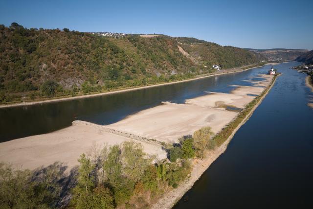 11 August 2026, Rhineland-Palatinate, Kaub: An aerial view, taken with a drone, showing low water levels exposing large sections of the sandbar surrounding the Zollburg Pfalzgrafenstein. Photo: Thomas Frey/dpa