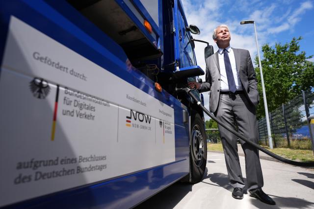 11 August 2026, Schleswig-Holstein, Neumunster: German Transport Minister Steffen Bilger stands next to an electric truck, learning about a ministry-funded project for publicly accessible charging infrastructure for electric cars and trucks, at the Bartels-Langness grocery store location. During his summer tour, Bilger visited various projects in northern Germany. Photo: Marcus Brandt/dpa