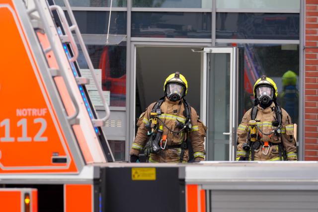 11 August 2026, Berlin: Firefighters emerge from a nursing home in Berlin's Biesdorf district, where a fire broke out this morning. The residents were brought to safety, according to a fire department spokesperson. Photo: Soeren Stache/dpa