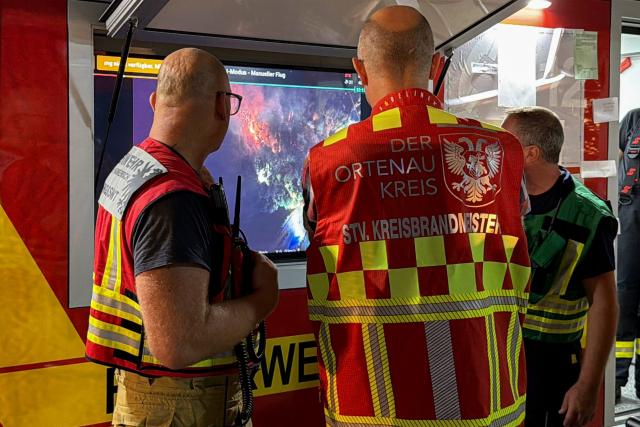 11 August 2026, Baden-Württemberg, Zell am Harmersbach: Emergency responders watch footage from a drone monitoring a forest fire near Zell am Harmersbach. Photo: Christian Klemm/Blaulichtreport Rottweil/dpa