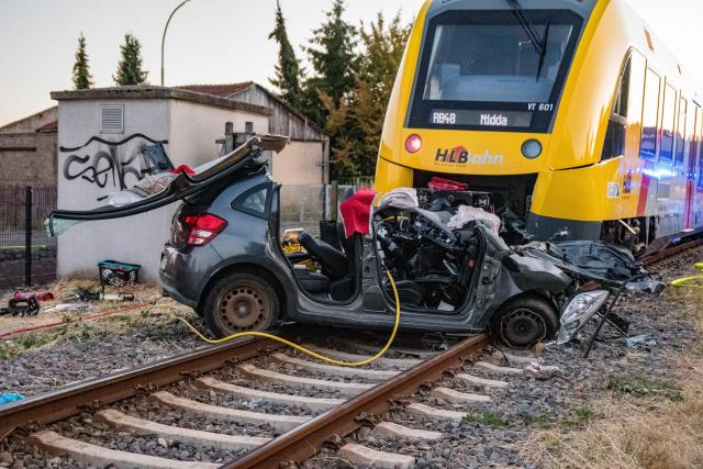11 August 2026, Hesse, Reichelsheim: A wrecked car and a train are seen on the tracks near Reichelsheim following an accident. Photo: Christoph Weiss/Fuldamedia/dpa