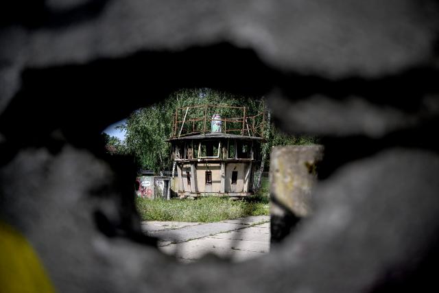 PRODUCTION - 04 August 2026, Berlin: Remains of a historic watchtower from the Berlin Wall, seen through a gate on Gartenstrasse. In 1961, the GDR began construction of the Berlin Wall. Photo: Britta Pedersen/dpa