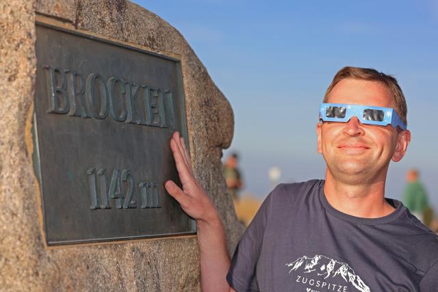 12 August 2026, Saxony-Anhalt, Schierke: Christian Schuder from Lower Saxony observes the partial solar eclipse in the Harz Mountains on the Brocken. Photo: Matthias Bein/dpa