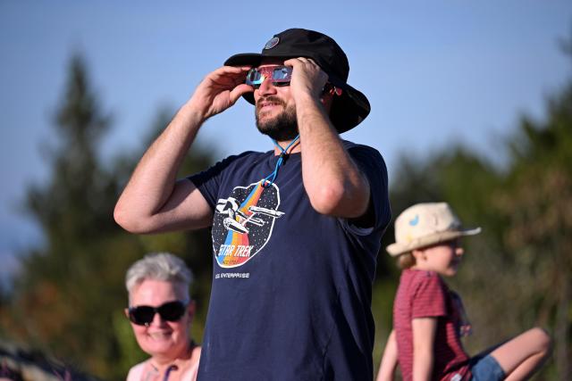 12 August 2026, Hesse, Feldberg: A person watches the solar eclipse on the Feldberg. Photo: JEB/dpa