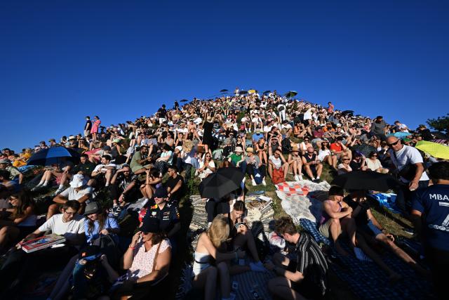 12 August 2026, Bavaria, Munich: People watch a partial solar eclipse on Olympiaberg in Munich's Olympiapark. Photo: Felix Hörhager/dpa