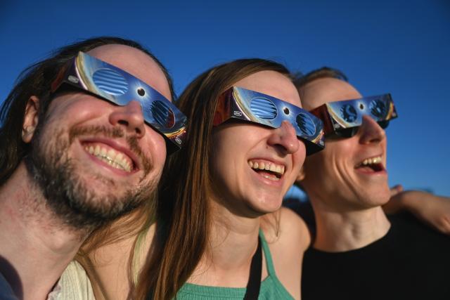 12 August 2026, Berlin: People are watching the partial solar eclipse in Berlin through special glasses. Photo: Elisa Schu/dpa