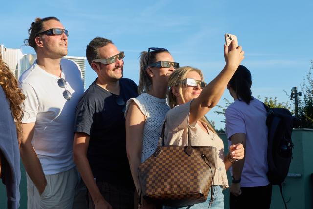 12 August 2026, Hamburg: Visitors watch the partial solar eclipse from the roof of the Grüner Bunker. Photo: Georg Wendt/dpa