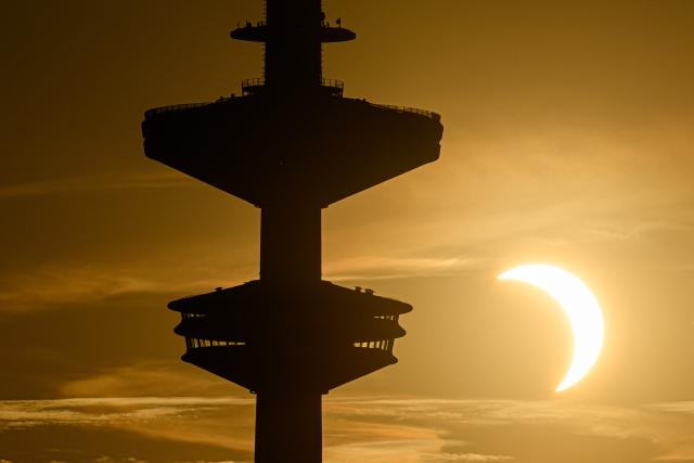 12 August 2026, Hamburg: The Moon passes in front of the Sun during a solar eclipse, as the Heinrich Hertz Tower can be seen in the foreground. Photo: Daniel Reinhardt/dpa