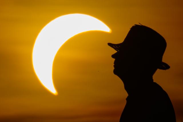12 August 2026, Brandenburg, Jacobsdorf: A man watches the partial solar eclipse in eastern Brandenburg. Photo: Patrick Pleul/dpa