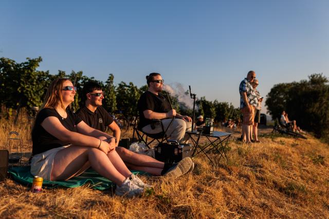 12 August 2026, Baden-Wuerttemberg, Ehrenkirchen: (L-R) Larissa, Pascal, and Philip watch the partial solar eclipse. Photo: Philipp von Ditfurth/dpa