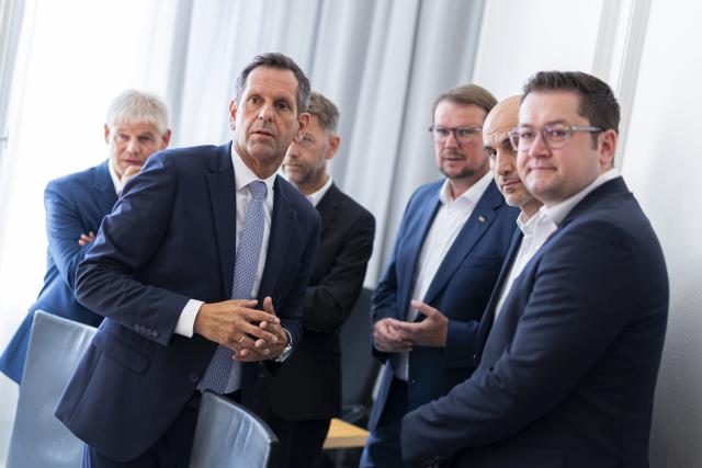 13 August 2026, Lower Saxony, Hanover: Frank Klingebiel (L-R), Mayor of Salzgitter; Olaf Lies, Minister-President of Lower Saxony; Dennis Weilmann, Mayor of Wolfsburg; Tim Kruithoff, Mayor of Emden; Belit Onay, Mayor of Hanover; and Thorsten Kornblum, Mayor of Braunschweig, are standing in the state government's guest house before the start of talks on Volkswagen. Photo: Michael Matthey/dpa