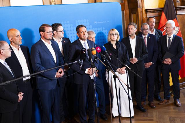13 August 2026, Lower Saxony, Hanover: Grant Hendrik Tonne (L-R), Minister of Economic Affairs of Lower Saxony; Belit Onay, Mayor of Hanover; Tim Kruithoff, Mayor of Emden; Thorsten Kornblum , Mayor of Braunschweig; Olaf Lies, Minister-President of Lower Saxony; Frank Klingebiel, Mayor of Salzgitter; Katharina Poetter, Mayor of Osnabrueck, and Dennis Weilmann, Mayor of Wolfsburg, stand in the state government's guest house during the closing remarks following discussions about Volkswagen with the mayors of cities hosting VW plants. Photo: Michael Matthey/dpa