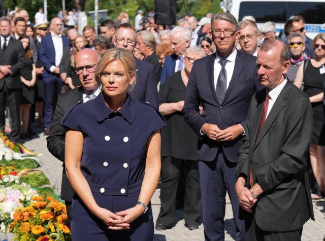 13 August 2026, Berlin: Bundestag President Julia Kloeckner (2-L) and Berlin's Governing Mayor Kai Wegner (L), as well as Minister of State for Culture Wolfram Weimer (2-R) stand side by side at the Berlin Wall Memorial before straightening the ribbons on the wreaths laid in front of the steel wall. Several events in Berlin are being held to commemorate the anniversary of the construction of the Berlin Wall. Photo: Sören Stache/dpa