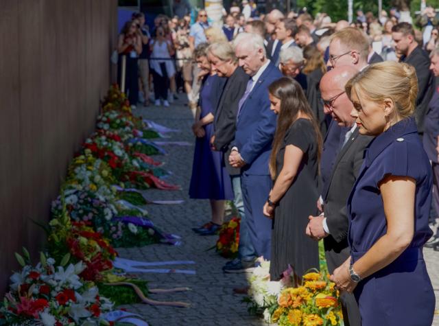 13 August 2026, Berlin: Bundestag President Julia Kloeckner (R) and Berlin's Governing Mayor Kai Wegner (2-R) stand side by side at the Berlin Wall Memorial before adjusting the ribbons on the wreath lying in front of the steel wall. Several events in Berlin are commemorating the anniversary of the construction of the Berlin Wall. Photo: Sören Stache/dpa